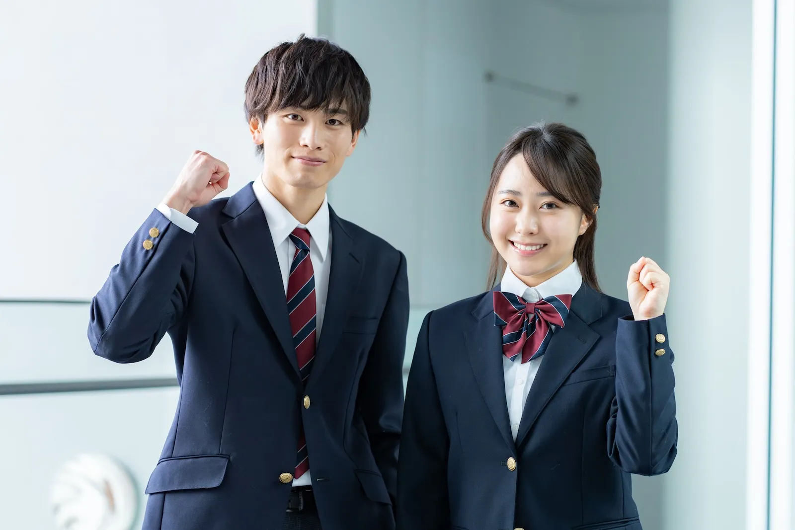 笑顔でガッツポーズをする制服姿の生徒たち