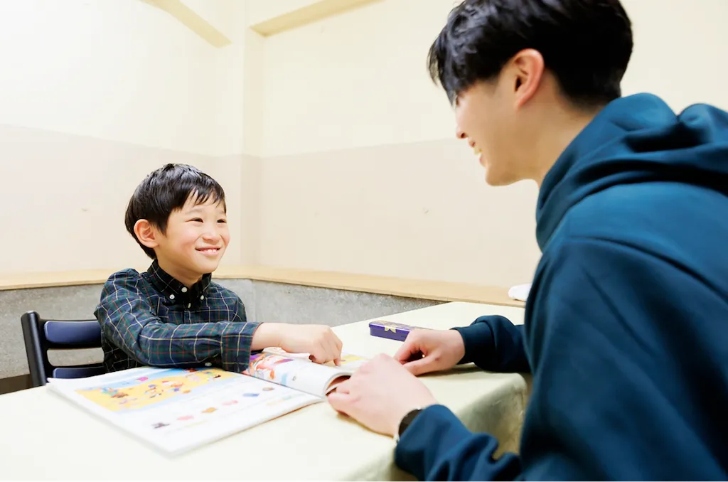 講師との会話を楽しみながら笑顔で英語を学ぶ小学生