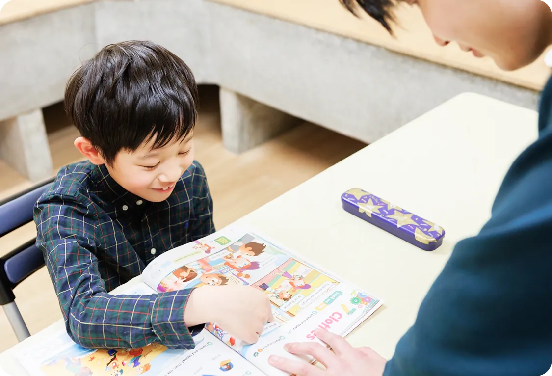 英語のテキストを使って講師と学ぶ小学生の個別レッスン